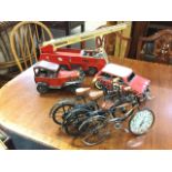 A Tonka fire engine; a model vintage car; three bicycle models - one with clock mounted to wheel;