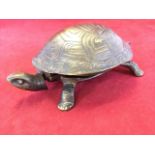 A bronze tortoise desk bell, the working mechanism operated by pushing head or tail. (7in x 2.5in)