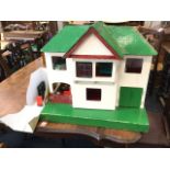 A childs dolls house with pitched roof, the front elevation hinging to reveal a furnished interior