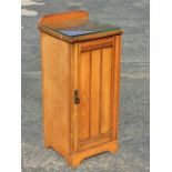 A Victorian ash pot cupboard with rounded upstand to moulded top, having reeded panelled door