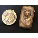 A circular brass vesta cast as a cat set with yellow glass eyes, with sprung hinged lid and striking