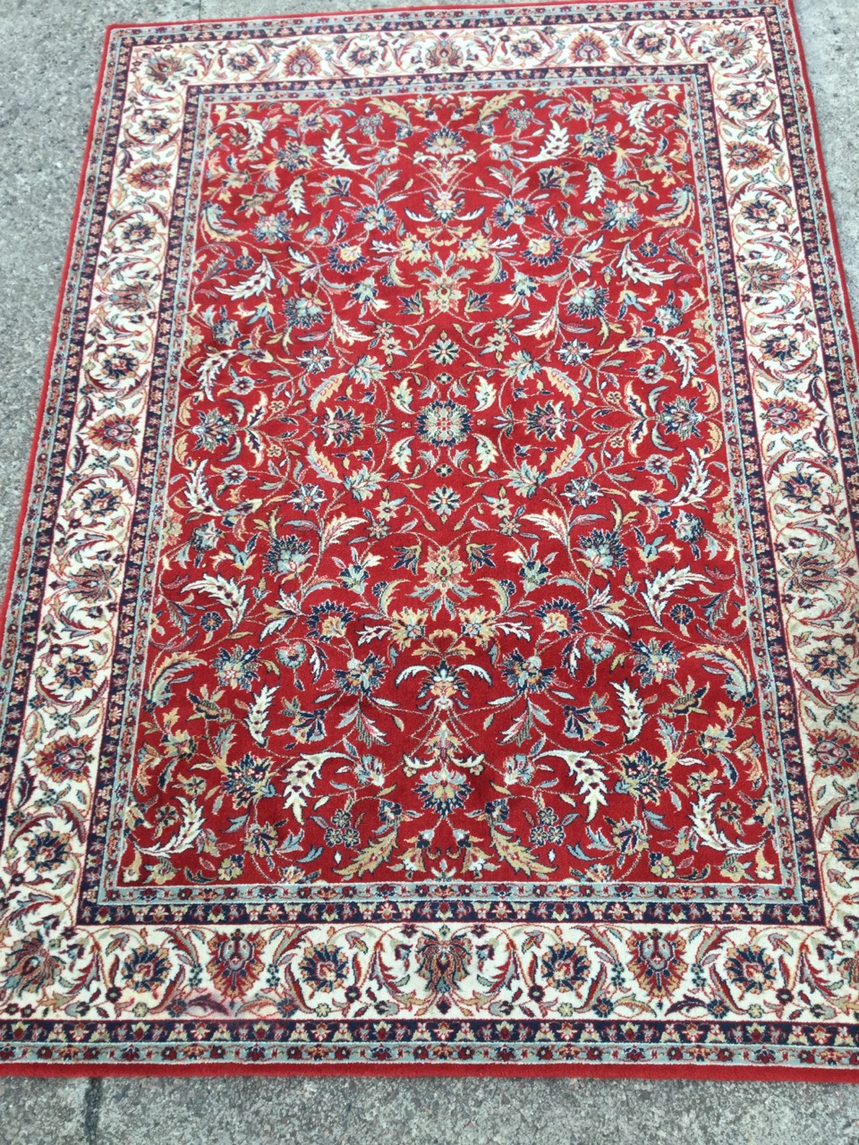 A Galileo oriental style wool rug, the red field woven with interlaced foliage within an ivory