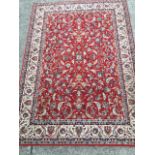 A Galileo oriental style wool rug, the red field woven with interlaced foliage within an ivory