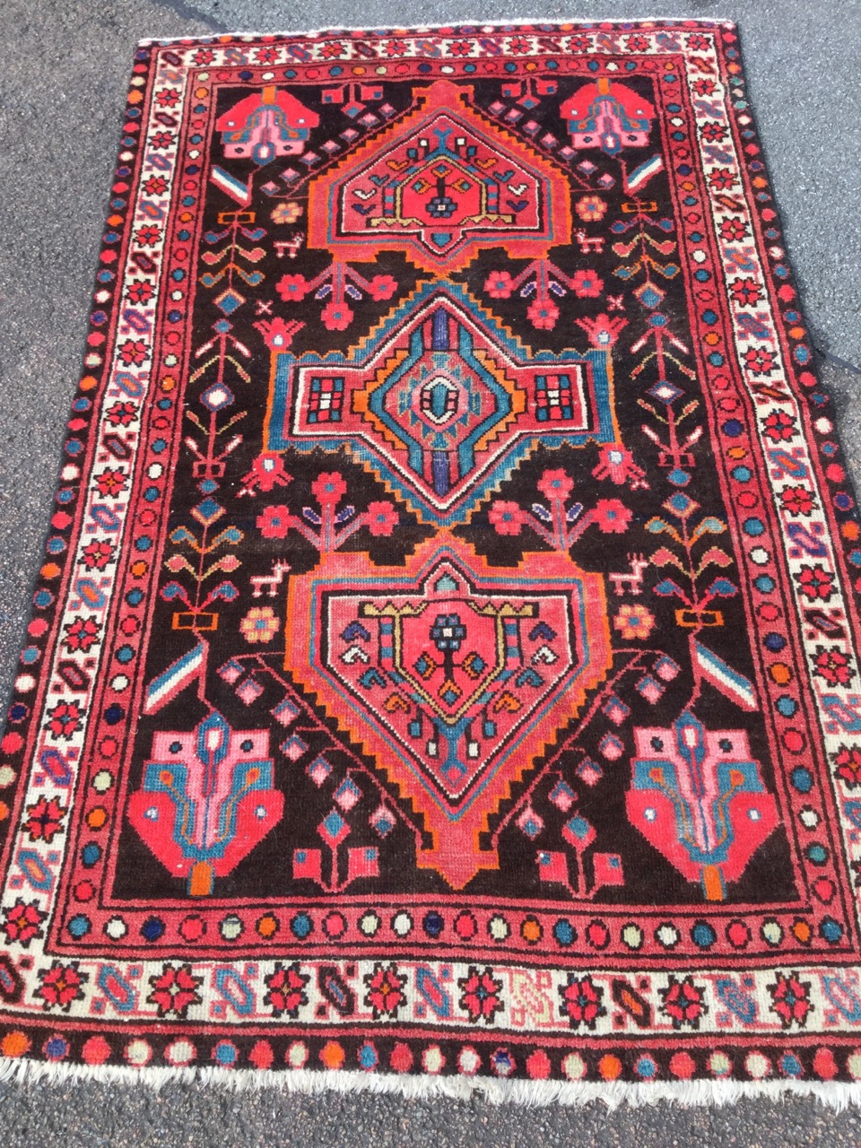 A oriental style wool rug woven with the serrated medallions in brown field with stylised flowers,