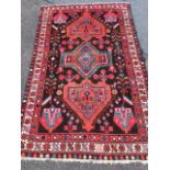 A oriental style wool rug woven with the serrated medallions in brown field with stylised flowers,