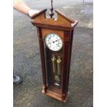 A Vienna style mahogany cased wallclock, the broken pediment framing a turned finial above a