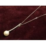 An 18ct white gold diamond & pearl pendant, the large pearl mounted on long hallmarked loop set with