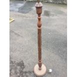 A carved oriental hardwood standard lamp, the turned column with leaf foliage on circular conforming