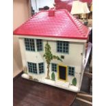 A 1960s wood dolls house, the tin front elevation sliding, the interior with four rooms papered. (