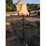 A stained standard lamp, the turned tapering column on circular moulded base with bun feet,