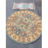 A circular rug woven with floral scrolled panel on green ground, within a conforming russet coloured