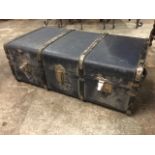 A rectangular 3ft school trunk with strap wood mounts and leather handles to ends.