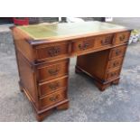 A reproduction mahogany pedestal desk, the rectangular moulded top with gilt tooled leather skiver