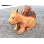 A douglas fir chainsaw carved squirrel, with singed tail and marble glass eyes. (22in)