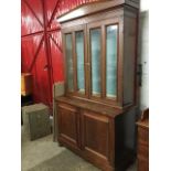 A nineteenth century mahogany bookcase, the triangular pediment above glazed doors enclosing