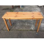 A rectangular pine table, the moulded top on turned legs. (51in x 17in x 27.5in)