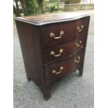 A late nineteenth century serpentine shaped mahogany chest, the crossbanded moulded top above