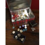 A tin of miscellaneous jewellery including earrings, brooches, bracelets, a cameo, enamel,