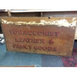 A rectangular Victorian glass advertising window, sign written 'Tobacconist Leather & Fancy Goods'