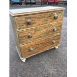 A Victorian pine chest of three long knobbed drawers raised on turned feet - formerly painted. (33.