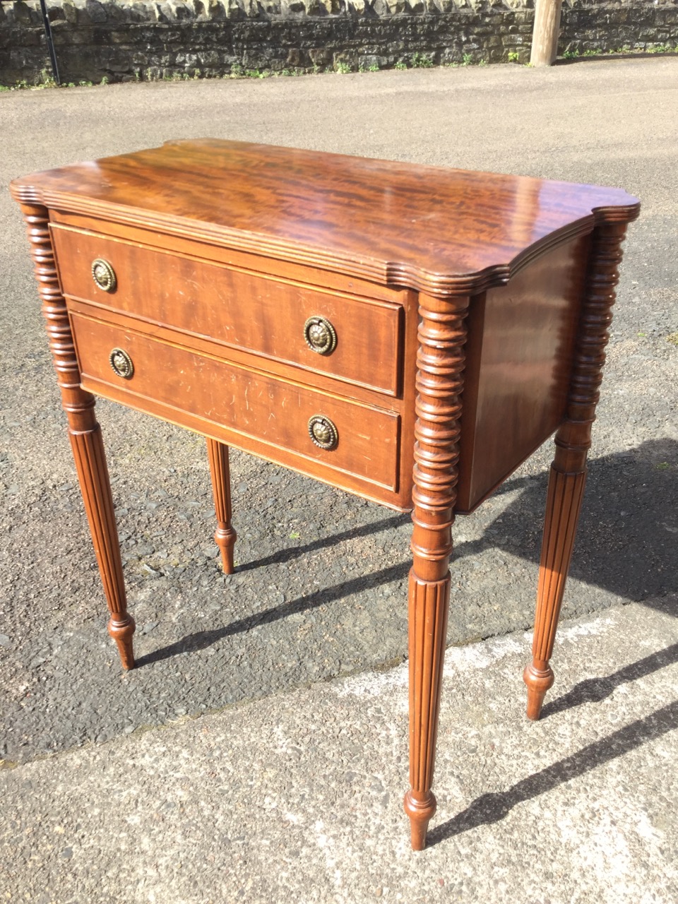 A mahogany side cabinet, the shaped top with ribbed edge above two cockbeaded drawers framed by