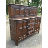 An Ercol oak court cupboard of dowel jointed construction, the top with two carved fielded