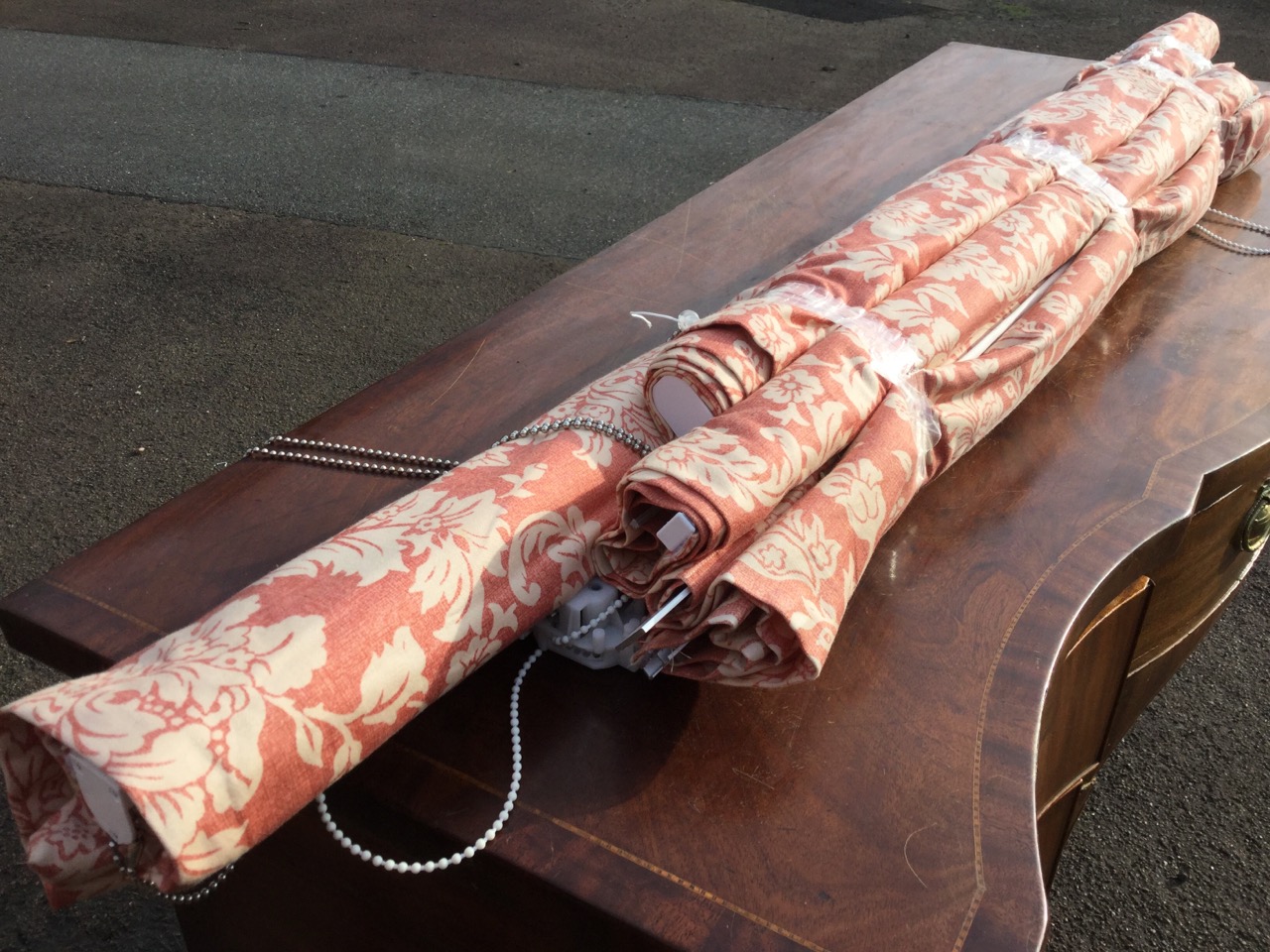 Four printed cotton blinds of floral design on red ground, removed from house complete with cords,