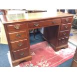 A mahogany kneehole desk, the rectangular moulded top with tooled leather skiver above three