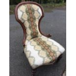 A Victorian mahogany saloon armchair, the upholstered spade back in moulded scrolled carved frame