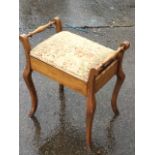 An Edwardian piano stool with rectangular upholstered hinged box seat framed by turned spindle