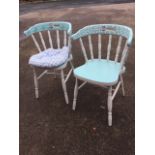 A pair of painted smokers bow style kitchen chairs, the rounded backs on spindles above solid saddle