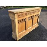 A remembrance oak shelf cabinet with three gothic arched panels above a moulded plinth. (57in x 10.