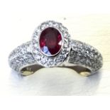 A 18ct white gold Burmese ruby & diamond ring, the fine oval bezel set ruby of one carat, framed