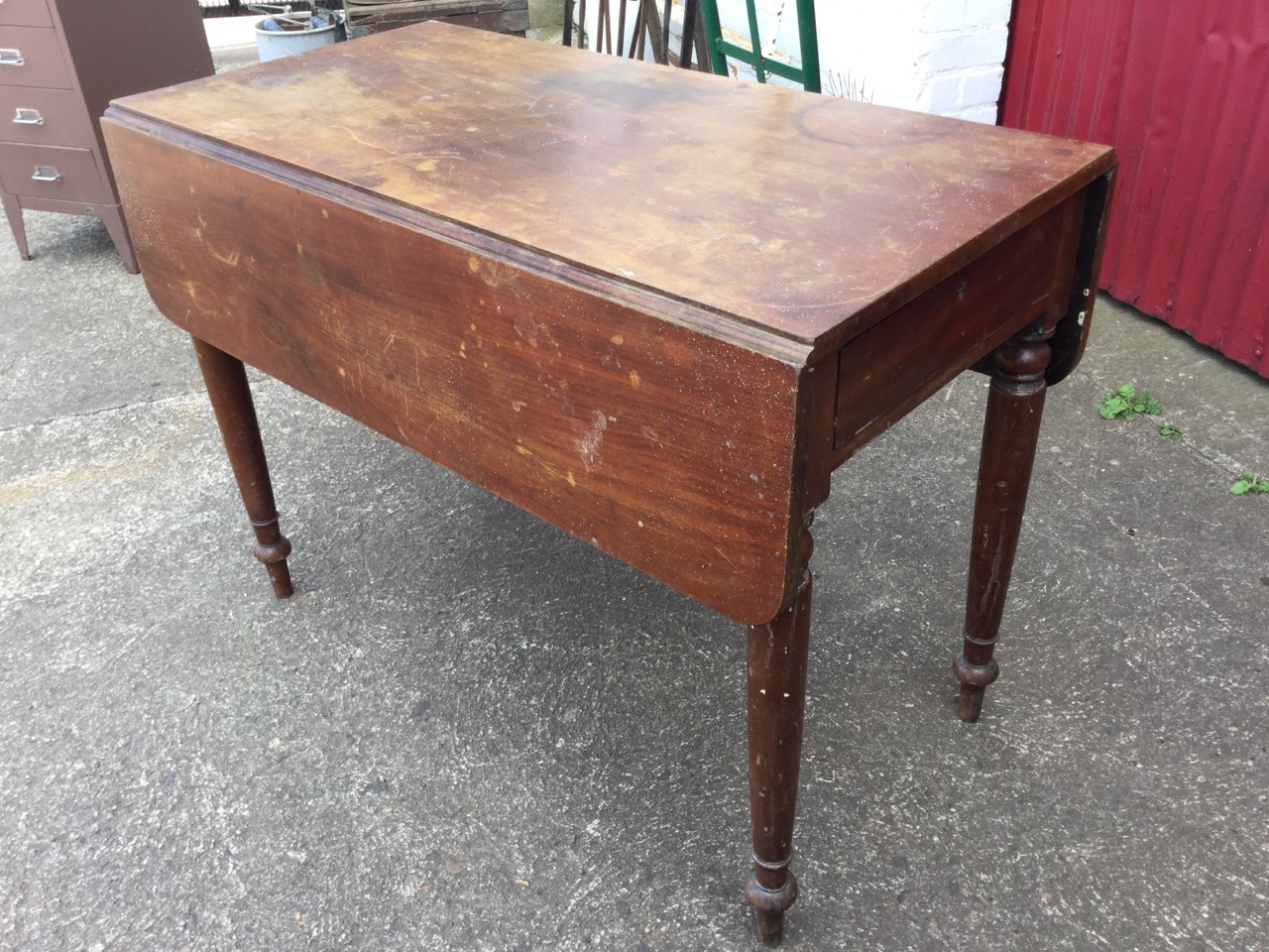 A Victorian mahogany pembroke table with two rounded drop leaves and frieze drawer, raised on turned