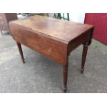 A Victorian mahogany pembroke table with two rounded drop leaves and frieze drawer, raised on turned