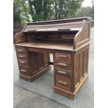 An oak rolltop desk by Lebus, the tambour enclosing a fitted interior above panelled pedestals