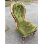 A Victorian button upholstered spoonback armchair, the moulded frame with foliate carving above a