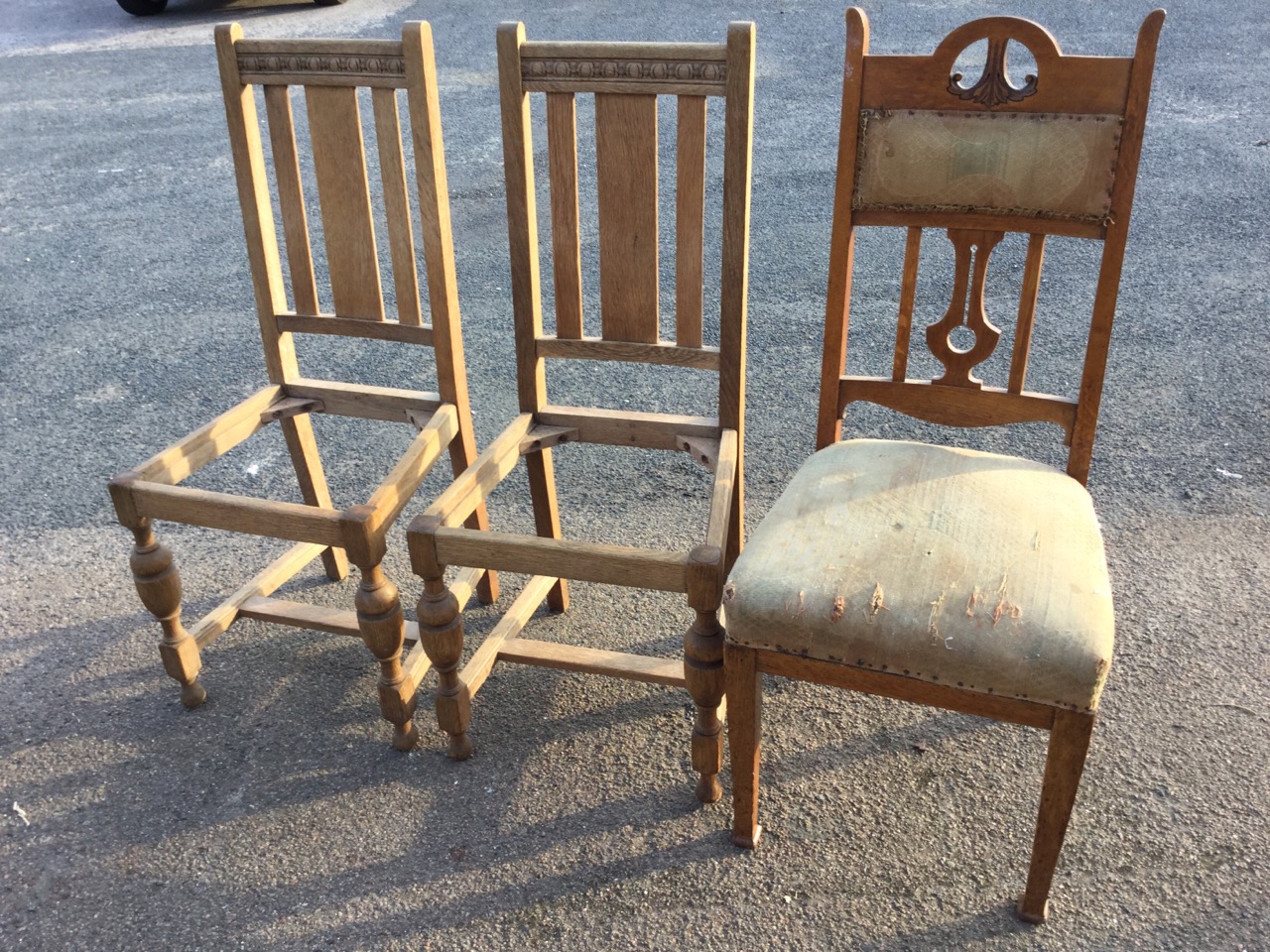 An art nouveau oak dining chair, the back with upholstered panel beneath scroll carved rail,