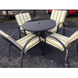 A circular glass top garden table and four armchairs on arched frames with loose cushions. (5)
