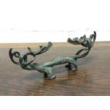 An ancient Chinese bronze rest, cast as a pair of entwined stylised dragons. (6.25in)