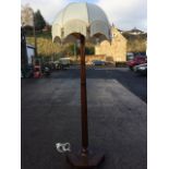 A hexagonal mahogany standard lamp, the tapering column on platform base with six bun feet,