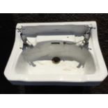 An Armitage Ware hand basin with canted corners, fitted with chrome hot & cold labelled taps. (