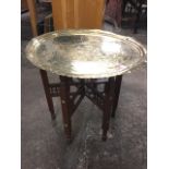 A circular eastern tray-top brass coffee table, engraved with couple in arched panel flanked by