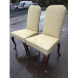 A pair of George II style walnut side chairs, the high upholstered backs above tapering seats,