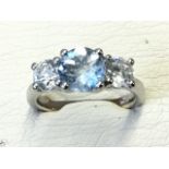 A platinum aquamarine & diamond three stone ring, the central aquamarine claw set stone weighing