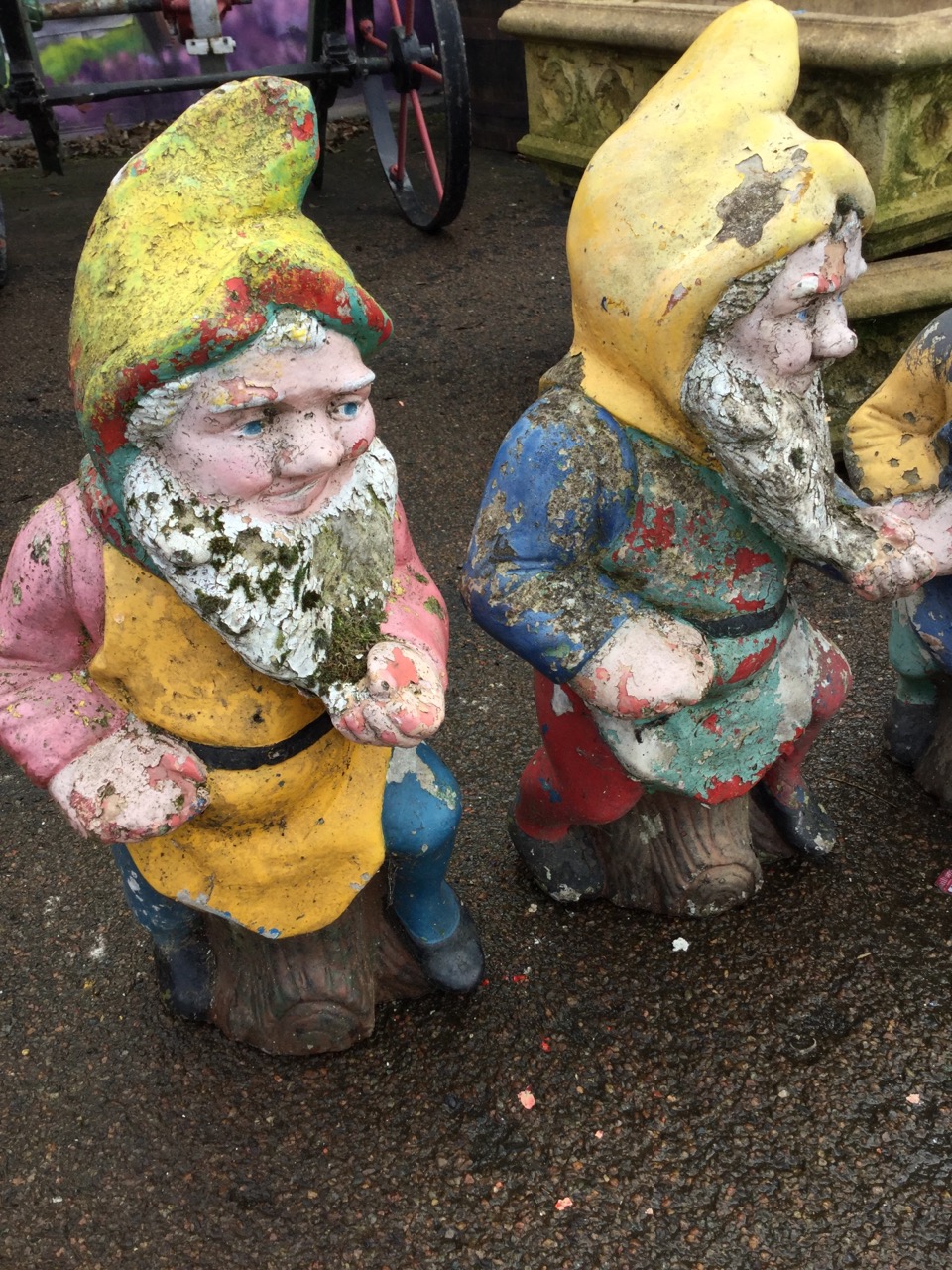 A set of three colourful garden gnomes, the bearded composition stone figures seated on logs. (23in) - Image 2 of 3