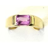 An 18ct yellow gold solitaire sapphire ring, the bezel set emerald cut pink sapphire weighing just