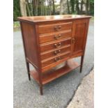 An Edwardian music cabinet with rectangular moulded top above five drop-down drawers mounted with