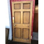 A heavy pine internal door with six moulded panels, fitted with bead moulded brass handles,