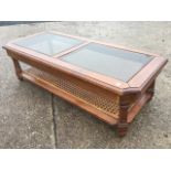 A rectangular walnut coffee table, the moulded cut-corner top with two plate glass panels above a